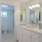 A bathroom with white cabinets and a toilet.