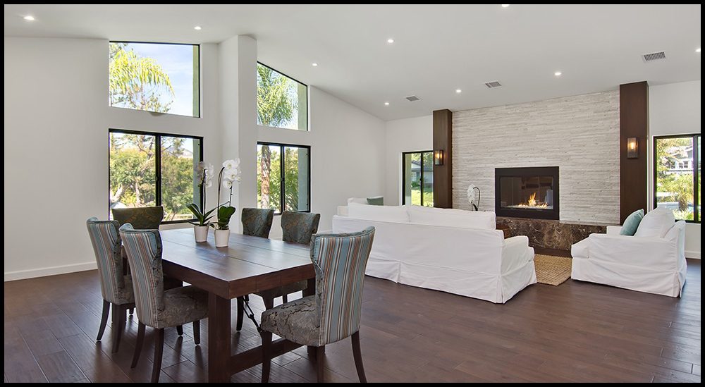 A living room with a fireplace and a dining table