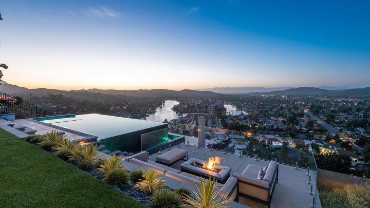 Scenic outdoor seating overlooking a river and cityscape at sunset.